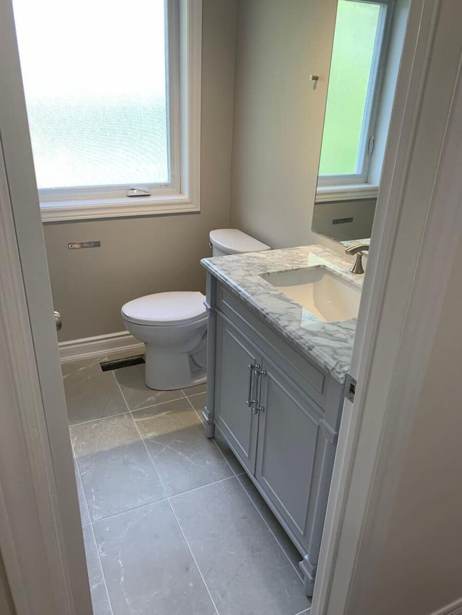 Finished bathroom renovation with modern cabinets, counters, tiles, and flooring